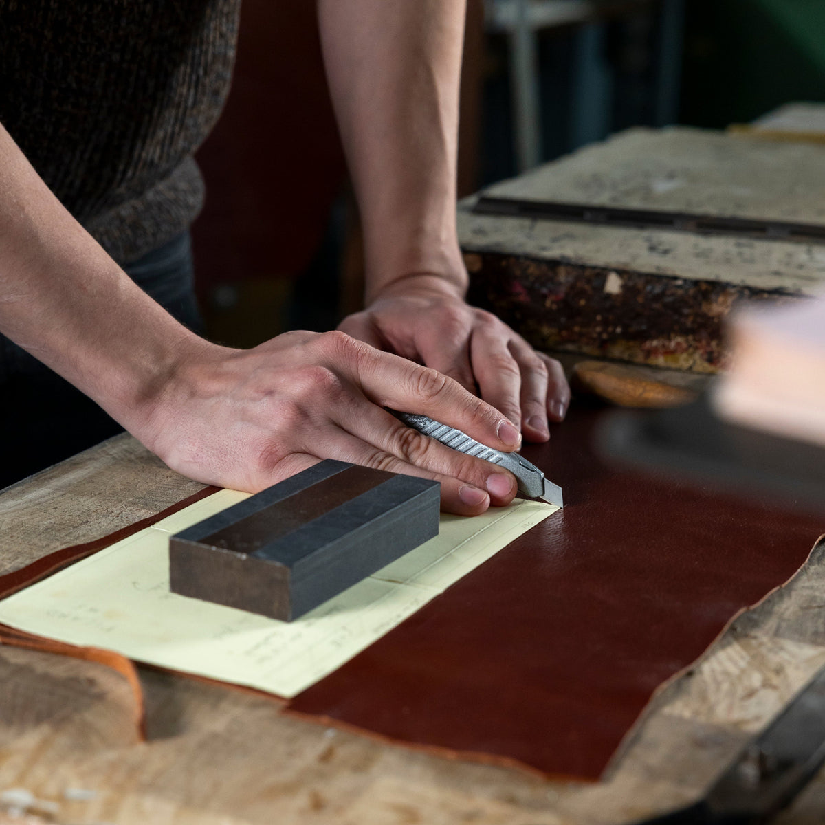 Handwerker schneidet Leder in der PICARD Manufaktur von Hand zu.